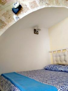 ポリニャーノ・ア・マーレにあるCasAntonia - Locazione Turisticaのベッドルーム1室(青いベッドカバー付)