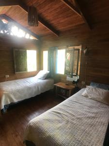 a bedroom with two beds and two windows at Casita de los Sueños in Cabuya +19 photos