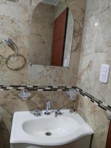 ein Bad mit einem Waschbecken und einem Spiegel in der Unterkunft Departamento Colon Entre Rios in Colón