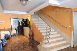 a staircase in a dining room with a table and chairs at Hostal Can Marinés in Sant Carles de la Ràpita