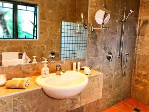 a bathroom with a sink and a shower at Coastal Chalet Suites Whangaroa in Kaeo +25 photos