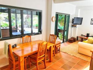 a dining room with a wooden table and chairs at Coastal Chalet Suites Whangaroa in Kaeo