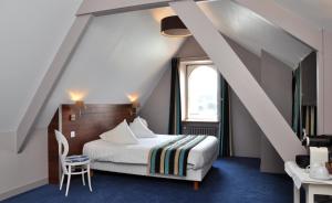 a hotel room with a bed and a staircase at Hôtel des Rochers in Perros-Guirec