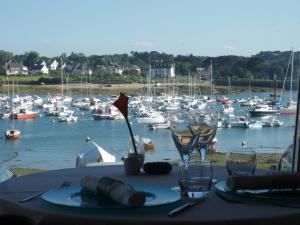 a table with glasses and boats in a marina at Hôtel des Rochers in Perros-Guirec