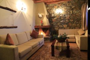 a living room with a couch and a stone wall at Remos Villas in Agios Pavlos