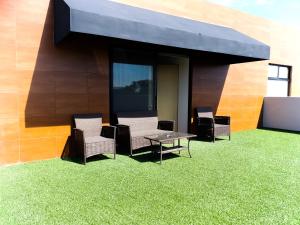 d'une terrasse avec des chaises, une table et de la pelouse. dans l'établissement ROOM Hotel & Suites, à Puebla