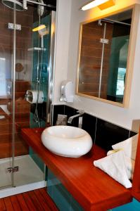 a bathroom with a sink and a glass shower at Hôtel des Rochers in Perros-Guirec