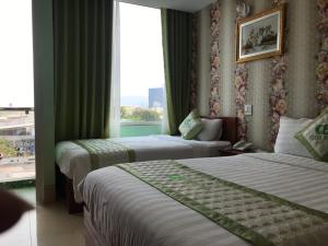 Habitación de hotel con 2 camas y ventana en Green Park Hotel Quy Nhon, en Quy Nhon