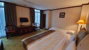 Rúm í herbergi á Rich Garden Hotel