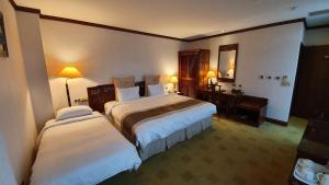Rúm í herbergi á Rich Garden Hotel