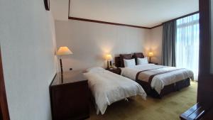 Rúm í herbergi á Rich Garden Hotel