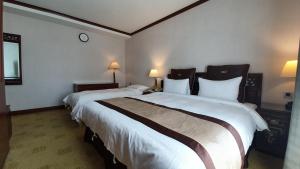 Rúm í herbergi á Rich Garden Hotel