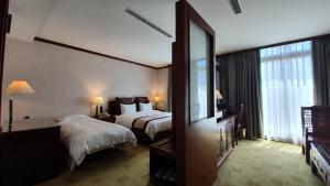 Rúm í herbergi á Rich Garden Hotel