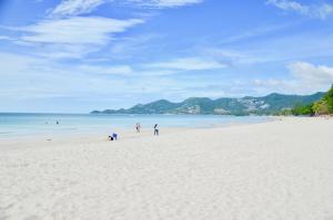 un grupo de personas de pie en una playa blanca en Al's Resort, en Chaweng