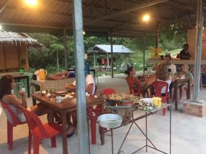 a group of people sitting at tables in an outdoor restaurant at Koh Phaluai Beach Bangalow in Ban Ko Nok Taphao +57 photos