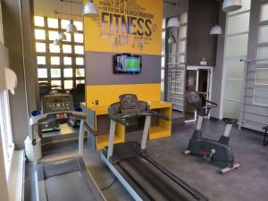 a gym with two tread machines and a tv at Mercure Sao Paulo Bela Vista in Sao Paulo