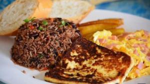 a plate of food with meat and scrambled eggs and toast at Campos Arenal Hotel in Fortuna