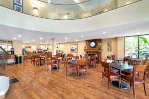 a restaurant with tables and chairs and a clock on the ceiling at Baymont by Wyndham Knoxville/Cedar Bluff in Knoxville