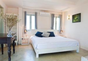 a bedroom with a white bed and a piano at Villa Duangchampa in Chiang Mai +103 photos