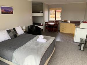 Un dormitorio con una cama con un sombrero blanco. en Ranfurly Holiday Park & Motels, en Ranfurly