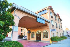 a large building with a sign for a hotel at Travelodge by Wyndham Pasadena Central in Pasadena