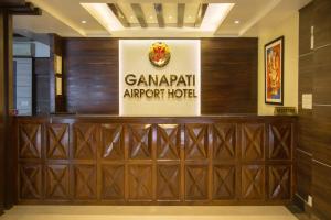 un panneau indiquant l'hôtel campari de l'aéroport derrière une porte en bois dans l'établissement Ganapati Airport Hotel, à Katmandou