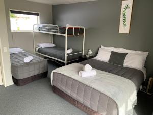 RanfurlyにあるRanfurly Holiday Park & Motelsのベッドルーム1室(ベッド2台、二段ベッド1組付)