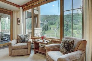 sala de estar con 2 sillas y ventana grande en Luxurious 2 Bd With Lift View In Beaver Creek Condo, en Beaver Creek