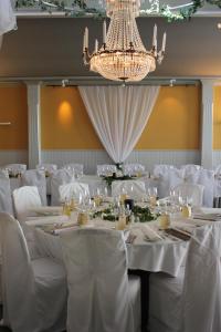 a room with white tables and chairs with a chandelier at Ronnums Herrgård in Vargön +78 photos