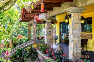 un porche de una casa con flores y plantas en La Terraza Guest House B&B en Grecia