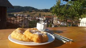 a plate with two pastries on a table with a cup of coffee at Къща за гости МЕЛИСА in Borino