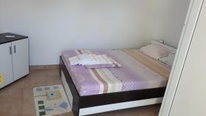 ein kleines Bett in einem Zimmer mit Spiegel in der Unterkunft La Olteanu in Vadu