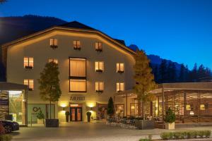 a large building in front of a building at Zur Post Residence Sexten in Sesto