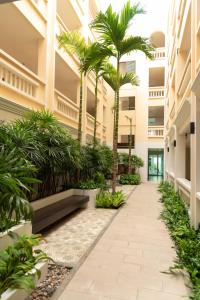 a hallway with palm trees in a building at Park 38 Hotel - SHA Plus in Phuket