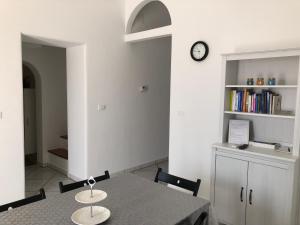 uma sala de jantar com uma mesa e um relógio na parede em A casa di nonna Lina em Polignano a Mare