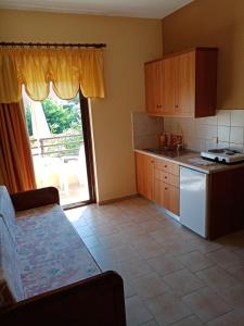 a kitchen with a refrigerator and a table and a window at John Apartments in Plataniás
