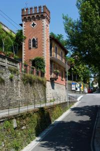 ein Gebäude mit einem Uhrturm an der Seite einer Straße in der Unterkunft B&B Torre Lara in Belgirate