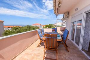 a patio with a table and chairs on a balcony at Apartments Milena 8 in Mandre