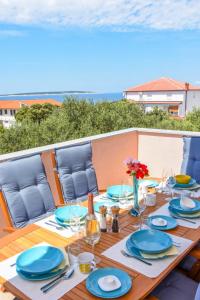 a wooden table with blue plates and glasses on it at Apartments Milena 8 in Mandre