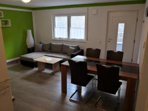 a living room with a table and a couch at Ferienwohnung Pfaffenberg in Oberteuringen