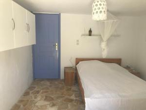 a bedroom with a bed and a blue door at Maison charme avec piscine privée, près de la mer à Sappounakeika, Tyros in Sapounakaíika