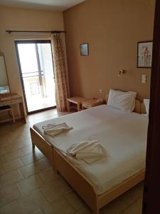 a bedroom with a large bed and a window at John Apartments in Platanias