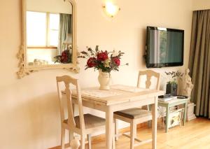 a dining room table with chairs and a vase with flowers at Room for Two in Richmond