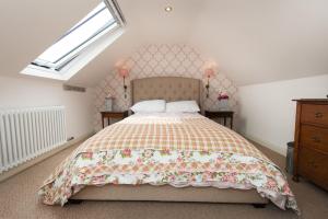 a bedroom with a bed with a floral bedspread at Granny's Attic at Cliff House Farm Holiday Cottages, in Whitby