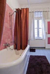 a bathroom with a tub and a shower with a curtain at B&B The Baron in Antwerp