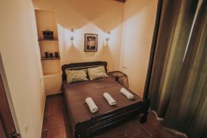a small bedroom with a bed with two towels on it at Telavi Tel Aviv in Tʼelavi