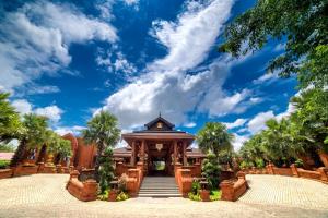 a building with palm trees and a blue sky at Heritage Bagan Hotel in Bagan