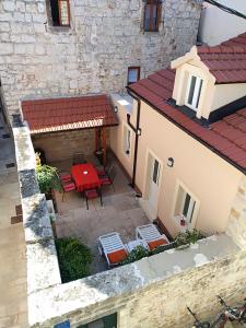 een patio met een rode tafel en stoelen bij Mirina in Stari Grad