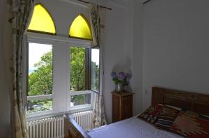 a bedroom with a bed and a large window at B&B Torre Lara in Belgirate