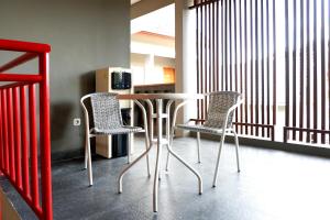 a table and two chairs in a room at Griya Damai Syariah Yogyakarta Mitra RedDoorz in Yogyakarta